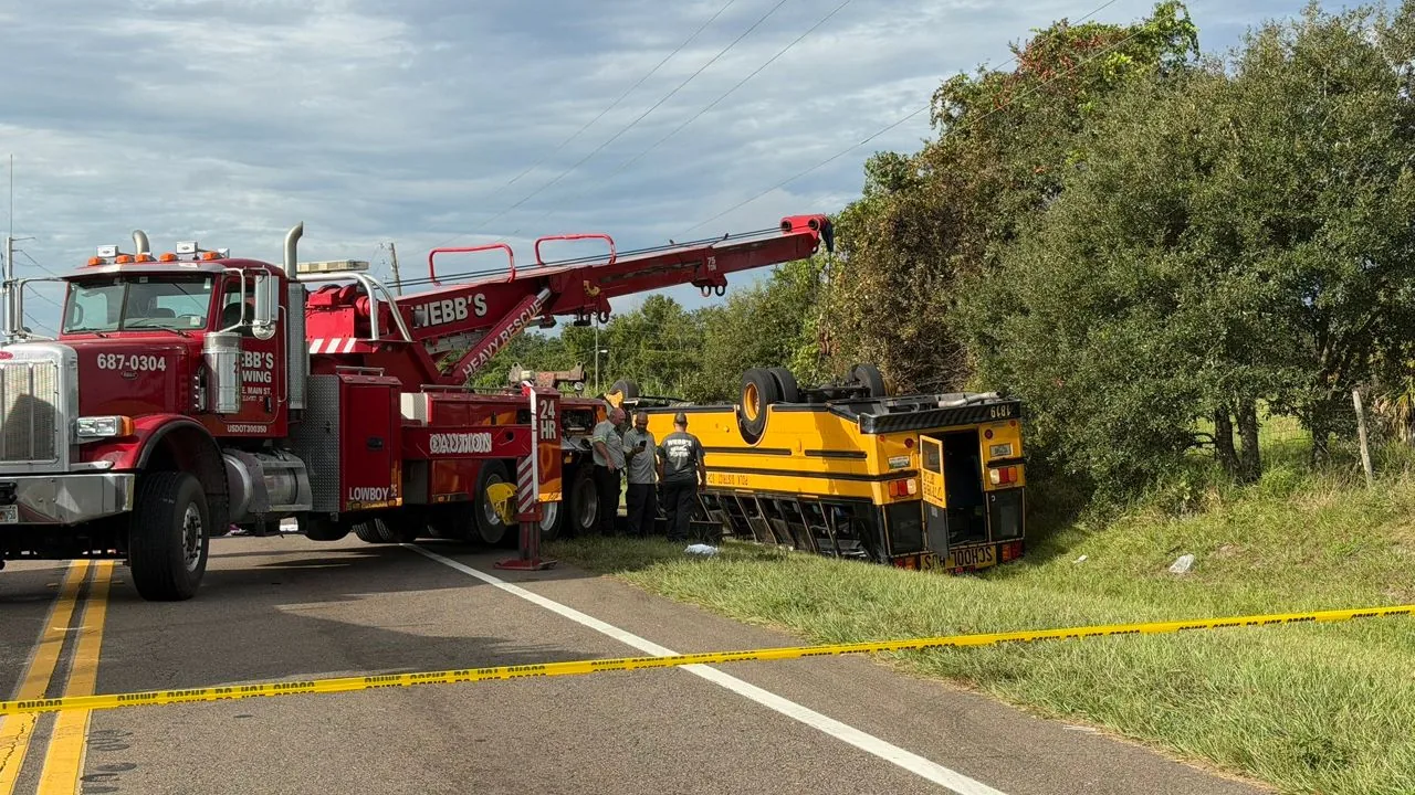 An overturned school bus lies in a ditch after a crash on Lucerne Park Road in Winter Haven
