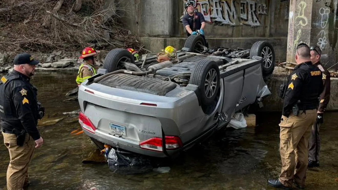 Emergency crews respond to an overturned car in Gunpowder Creek near Camp Ernst Bridge